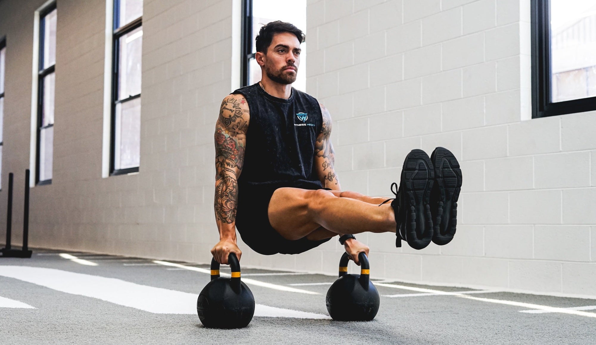 man working out using kettlebells for isometric l-sit exercise